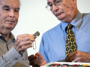 Larry McDaniel, of Jacksonville, Fla., left, and his brother, Charles McDaniel, of Indianapolis, sons of Master Sgt. Charles Hobert McDaniel who died in the Korean War in 1950, are presented their father's dog tag by an official of the Army's Past Conflicts Casualty Office, Wednesday, Aug. 8, 2018, in Arlington, Va. The dog tag was among remains recently repatriated from North Korea.