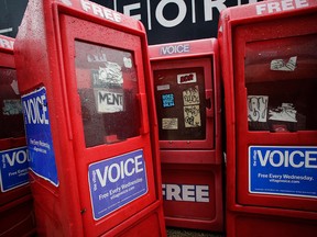 In this Nov. 27, 2013 photo, plastic newspaper boxes for The Village Voice stand along a Manhattan sidewalk in New York.