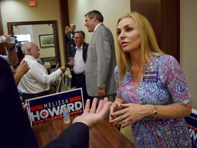 In this Tuesday, July 17, 2018 file photo, Melissa Howard who is running for the District 73 State House seat being vacated by state Rep. Joe Gruters meets with voters during a "meet the candidates" event at Gold Coast Eagle Distriburing in Lakewood Ranch, Fla.