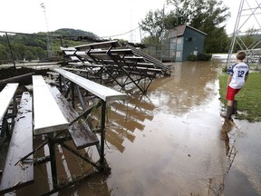 Baseball player Bo Milutinovich, 13, of Coon Valley, Wis. takes in the flood damage at Veterans Memorial Park in Coon Valley, Wis., Tuesday, Aug. 28, 2018, where torrential rains caused widespread flooding from Coon Creek.