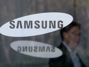 An employee walks past logos of the Samsung Electronics Co. at its office in Seoul, South Korea on April 6, 2018.