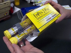 A pharmacist holds a package of EpiPen epinephrine auto-injectors, a Mylan product, in Sacramento, Calif., July 8, 2016.