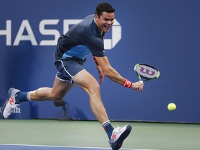 Milos Raonic, of Canada, returns a shot to John Isner, of the United States, during the fourth round of the U.S. Open tennis tournament, Sunday, Sept. 2, 2018, in New York. (AP Photo/Jason DeCrow)