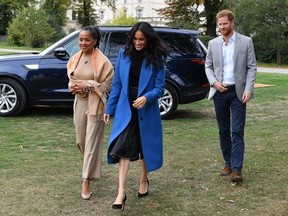 Meghan, Duchess of Sussex (C) arrives with her mother Doria Ragland (L) and Prince Harry, Duke of Sussex to host an event to mark the launch of a cookbook with recipes from a group of women affected by the Grenfell Tower fire at Kensington Palace on September 20, 2018 in London, England.