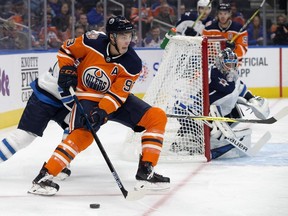 The Edmonton Oilers' Ryan Nugent-Hopkins (93) battles the Winnipeg Jets' Joe Morrow (70) during first period pre-season NHL action at Rogers Place, Thursday, Sept. 20, 2018.