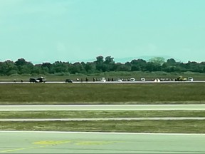 In this picture taken with a mobile phone through the window of a plane shows a French gendarmes and police arresting a man on the tarmac of Lyon's Saint-Exupery airport after he managed to get in the runways with his car without doing any injury, on September 10, 2018 in Colombier-Saugnieu.