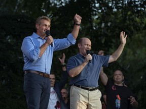 Jeff Flake, R- Ariz., left , and Sen. Chris Coons, D-Del, stand together as they address festival participants during the 2018 Global Citizen Festival Saturday, Sept. 29, 2018, in New York.