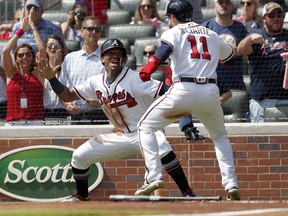 Atlanta Braves' Ronald Acuna Jr., left, and Ender Inciarte celebrate after scoring on a two-run base hit by Freddie Freeman in the second inning of a baseball game against the Philadelphia Phillies, Saturday, Sept. 22, 2018, in Atlanta.