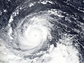 In this Wednesday, Sept. 12, 2018, NASA satellite image, Super Typhoon Mangkhut churns west towards the Philippines. Philippine officials have begun evacuating thousands of people in the path of the most powerful typhoon this year, closing schools and readying bulldozers for landslides.