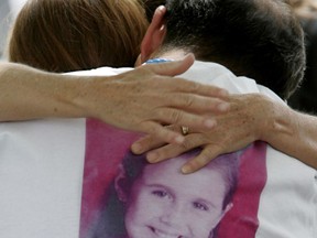 In this April 25, 2012, file photo, Sergio Celis, wearing a shirt with a picture of his missing 6-year-old daughter, Isabel, gets a hug from a volunteer near their home in Tucson, Ariz.