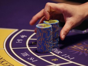 In this Sept. 20, 2012 file photo, a croupier counts the chips at a baccarat gaming table inside a casino during the opening day of Sheraton Macao Hotel at the Sands Cotai Central in Macau.(AP Photo/Kin Cheung, File)