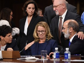 Christine Blasey Ford takes a break in her testimony before the U.S. Senate Judiciary Committee, Thursday, Sept. 27, 2018 on Capitol Hill in Washington. Lawyers seated are Debra Katz and Michael Bromwich. (/ )