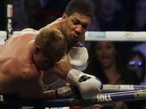 British boxer Anthony Joshua, rear, fights Russian boxer Alexander Povetkin in their WBA, IBF, WBO and IBO heavyweight titles fight at Wembley Stadium in London, Saturday, Sept. 22, 2018.