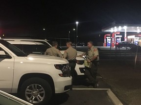 Kern County Sheriff's deputies gather near the scene, Wednesday, Sept. 12, 2018, in southeast Bakersfield, Calif., where authorities say a gunman killed multiple people.