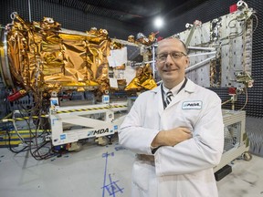 MDA's President Mike Greenley is seen in front of one of three RADARSAT Constellation Mission spacecrafts being built for the Canadian Space Agency at the company's facility in Sainte-Anne-de-Bellevue, Quebec on Tuesday Jan. 30, 2018.