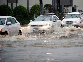 Cars slowly move through the flooded intersection of Jefferson Ave. and Harborview Ave. in south Stamford, Conn. on Tuesday, Sept. 25, 2018.