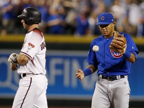Chicago Cubs shortstop Addison Russell, right, flips the ball in the air after tagging out Arizona Diamondbacks' Paul Goldschmidt, left, trying to steal Monday, Sept. 17, 2018, in Phoenix.