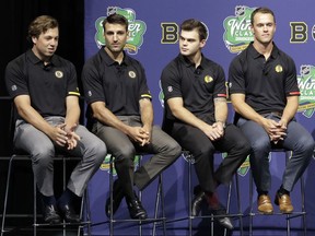 Boston Bruins' Charlie McAvoy, left, speaks as teammate Patrice Bergeron, second from left, and Chicago Blackhawks' Alex DeBrincat and Jonathan Toews, right, listen during a news conference Thursday, Sept. 6, 2018, in Chicago about the NHL Winter Classic hockey game.