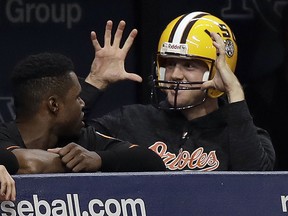 Baltimore Orioles relief pitcher David Hess gestures as he wears an LSU football helmet in the dugout against the Tampa Bay Rays Friday, Sept. 7, 2018, in St. Petersburg, Fla. (AP Photo/Chris O'Meara)