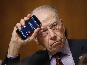Senate Judiciary Committee Chairman Chuck Grassley of Iowa holds up a timer on a smartphone during a Senate Judiciary Committee hearing on Supreme Court nominee Judge Brett Kavanaugh, Friday, Sept. 28, 2018, on Capitol Hill in Washington.