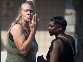 A woman blows a kiss to residents at an apartment complex, Monday, Sept. 3, 2018, in San Bernardino, Calif., where a shooting occurred during a dice game on Sunday night.