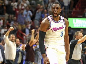 Heat guard Dwyane Wade screams with the crowd after scoring the winning basket to defeat the 76ers in an NBA game in Miami, Feb. 27, 2018.