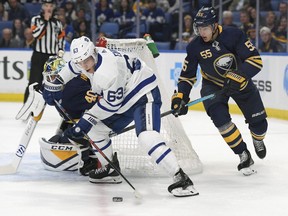 Maple Leafs centre Tyler Ennis is chased by defenceman Rasmus Ristolainen as he handles the puck beside the Sabres net on Saturday night in Buffalo.