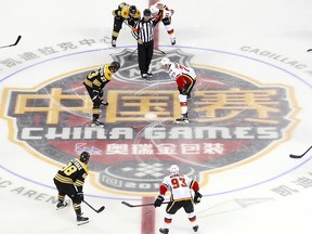 Jakob Forsbacka Karlsson of the Boston Bruins, centre left, and Mark Jankowski of the Calgary Flames face off at the start of their 2018 NHL China Games hockey game in Beijing, China, Wednesday, Sept. 19, 2018.