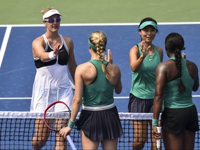 In this file photo, Gabriela Dabrowski of Canada and Yifan Xu of China congratulate Eugenie Bouchard of Canada and Sloane Stephens for their victory during day one of the Rogers Cup at IGA Stadium on August 6, 2018 in Montreal. (Minas Panagiotakis/Getty Images)