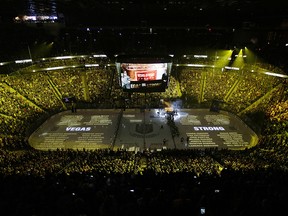 The names of people killed during the mass shooting in Las Vegas last year are projected on the ice during a ceremony before a game between the Vegas Golden Knights and the San Jose Sharks, Saturday, March 31, 2018, in Las Vegas. (AP Photo/John Locher)
