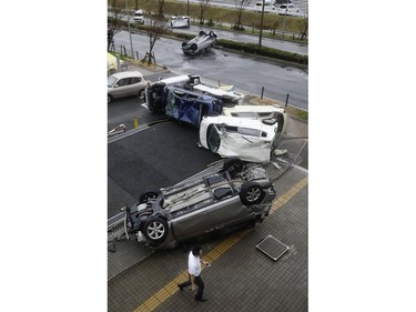 Overturned cars are seen on street following a powerful typhoon in Osaka, western Japan, Tuesday, Sept. 4, 2018.