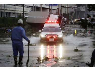 A police car makes through a flooded road following a powerful typhoon in Osaka, western Japan, Tuesday, Sept. 4, 2018.