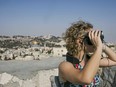 In this Monday, Sept. 3, 2018 photo, released by the Tower of David Museum, a visitor uses goggles on a new virtual reality tour that allows visitors to experience how archaeologists believe Jerusalem looked 2,000 years ago. The museum, which is housed in the Old City's ancient stronghold, plans to launch the high-tech guided tour in September ahead of the Jewish holiday of Sukkot.