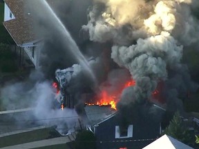 In this image take from video provided by WCVB in Boston, flames consume the roof of a home in Lawrence, Mass, a suburb of Boston, Thursday, Sept. 13, 2018. (WCVB via AP)