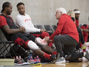 Raptors' Kawhi Leonard (left) gets his knees iced as he speaks to teammate Norman Powell during a team practice in Burnaby, B.C., Tuesday, Sept. 25, 2018. (THE CANADIAN PRESS)