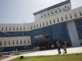 Security forces gather at the headquarters of the national oil company after an attack by gunmen in Tripoli, Libya, Monday, Sept. 10, 2018. Officials say security forces of Libya's U.N.-backed government stormed the building in the capital Tripoli after gunmen had earlier gone in, taking hostages and starting a fire. They say at least one explosion rocked the building soon after the gunmen stormed it, starting the blaze that swiftly spread through the lower floors.