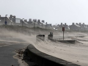 Strong winds whip sand across the seafront road at Troon Beach in Northern Ireland, as storm weather hits the area Wednesday Sept. 19, 2018.