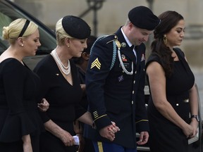 From left, Meghan McCain, Cindy McCain, Jimmy McCain and his wife Holly pause as they watch the casket of Sen. John McCain, R-Ariz., arrive at the Washington National Cathedral in Washington, Saturday, Sept. 1, 2018, for a memorial service. McCain died Aug. 25 from brain cancer at age 81.