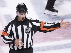 In this photo taken Sept. 17, 2018, referee Wes McCauley calls a penalty as the Montreal Canadiens face the New Jersey Devils during preseason action in Montreal. (Paul Chiasson/The Canadian Press via AP)