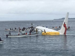 Local fishing boats move in to recover the passengers and crew of Air Niugini flight following the plane crashing into the sea on its approach to Chuuk International Airport in the Federated States of Micronesia., Friday, Sept. 28, 2018.