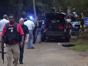 Law enforcement agents secure the scene of a shooting in Brookhaven, Miss., where two police officers were killed Saturday morning, Sept. 29, 2018.  A suspect was wounded and was taken into custody.
