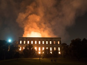 People watch as flames engulf the 200-year-old National Museum of Brazil, in Rio de Janeiro, Sunday, Sept. 2, 2018.