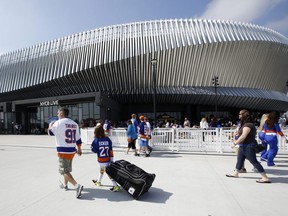 In this Sept. 17, 2017, file photo, hockey fans make their way toward the entrances of the renovated NYCB Live Nassau Coliseum in Uniondale, N.Y., before a preseason NHL game between the Islanders and Flyers.