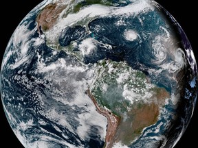 This enhanced satellite image provided by NOAA shows Hurricane Florence, third from right, in the Atlantic Ocean on Sunday, Sept. 9, 2018. At right is Tropical Storm Helene, and second from right is Tropical Storm Isaac. (NOAA via AP)