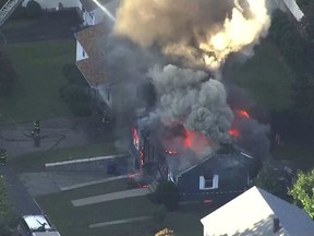 In this image take from video provided by WCVB in Boston, firefighters battle a raging house fire in Lawrence, Mass, a suburb of Boston, Thursday, Sept. 13, 2018. (WCVB via AP)