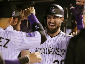 Colorado Rockies' David Dahl (26) is congratulated by teammates in the dugout after hitting a three run home run against the Philadelphia Phillies during the third inning of a baseball game on Tuesday, Sept. 25, 2018, in Denver.