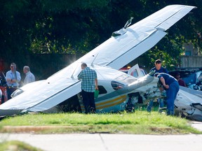Investigators look at a small plane that crashed just west of Highway 6, Wednesday, Sept. 19, 2018, in Sugar Land, Texas.