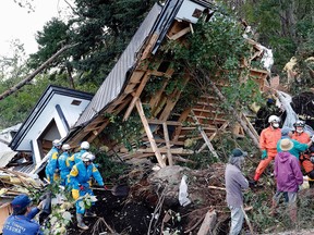 Rescuers work at the site of a landslide in Atsuma town, Hokkaido, northern Japan Thursday, Sept. 6, 2018.