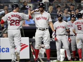 Boston Red Sox's Oscar Hernandez (28) bumps forearms with Xander Bogaerts after Hernandez's sacrifice fly drove in Ian Kinsler, right, during Tuesday, Sept. 18, 2018, in New York. (AP Photo/Julio Cortez)