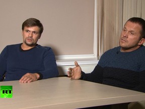 In this video grab provided by the RT channel on Thursday, Sept. 13, 2018, Ruslan Boshirov, left, and Alexander Petrov attend their first public appearance in an interview with the RT channel in Moscow, Russia.